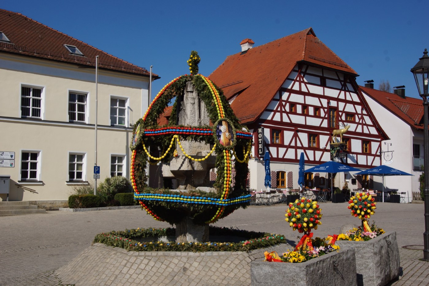 Ortskern von Berg bei Neumarkt mit Fachwerkhaus und österlich geschmücktem Brunnen
